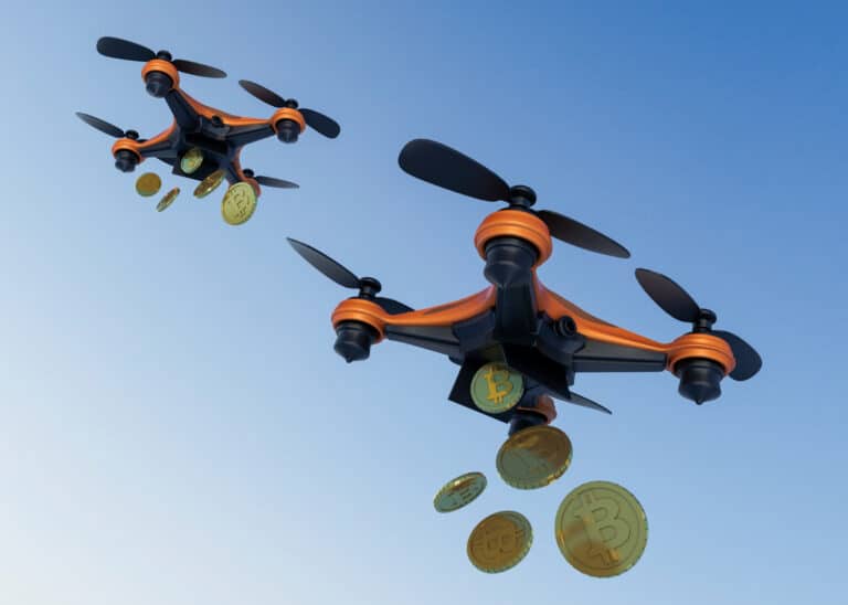 Deux drones en vol larguant des tokens de Bitcoin, illustrant la distribution de cryptomonnaies à travers le concept d’airdrop.