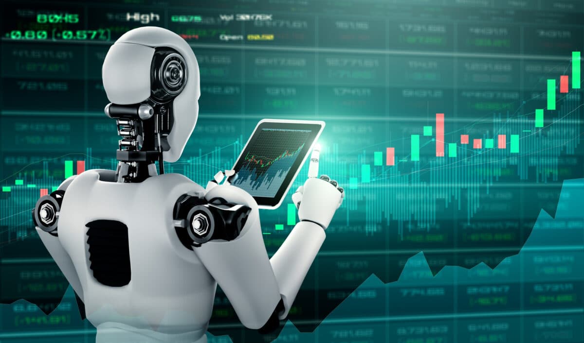 Robot analysant un graphique boursier sur tablette devant un écran de données financières.