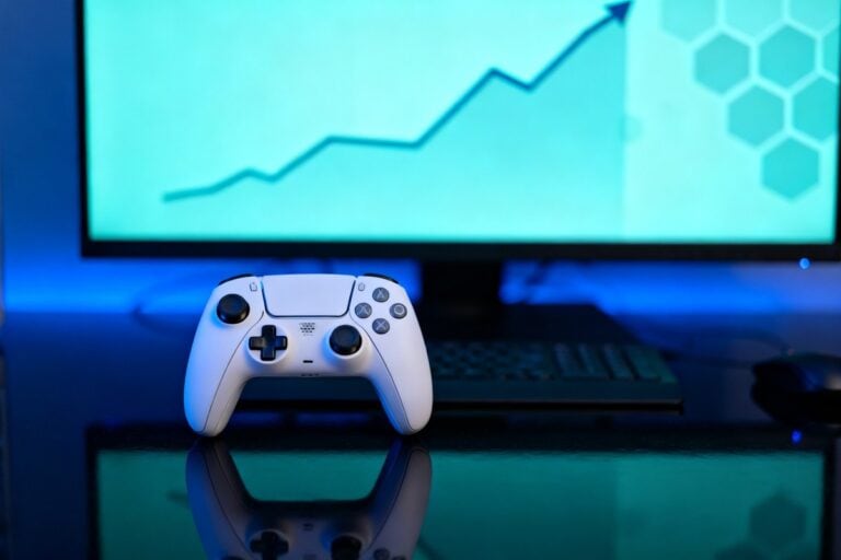 Manette de jeu blanche posée devant un écran affichant une courbe ascendante
