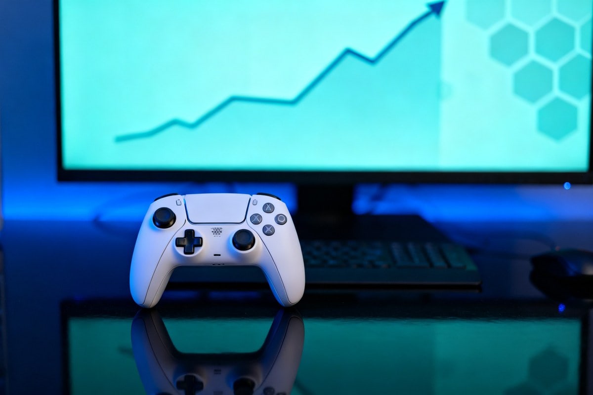 Manette de jeu blanche posée devant un écran affichant une courbe ascendante